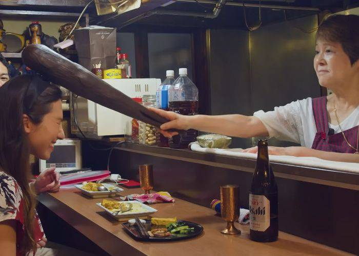 The host of a charming snack bar bonking Shizuka on the head with a big club.